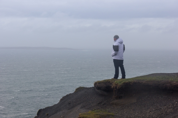Visitor at Cliffs of Moher looks out at the vista beyond